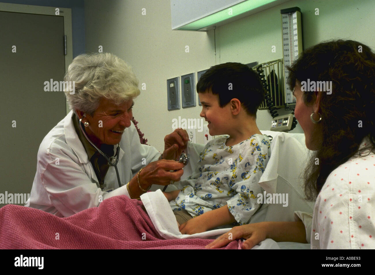 Nurse ministers to boy in Flagler Hospital Florida while mother looks on Stock Photo