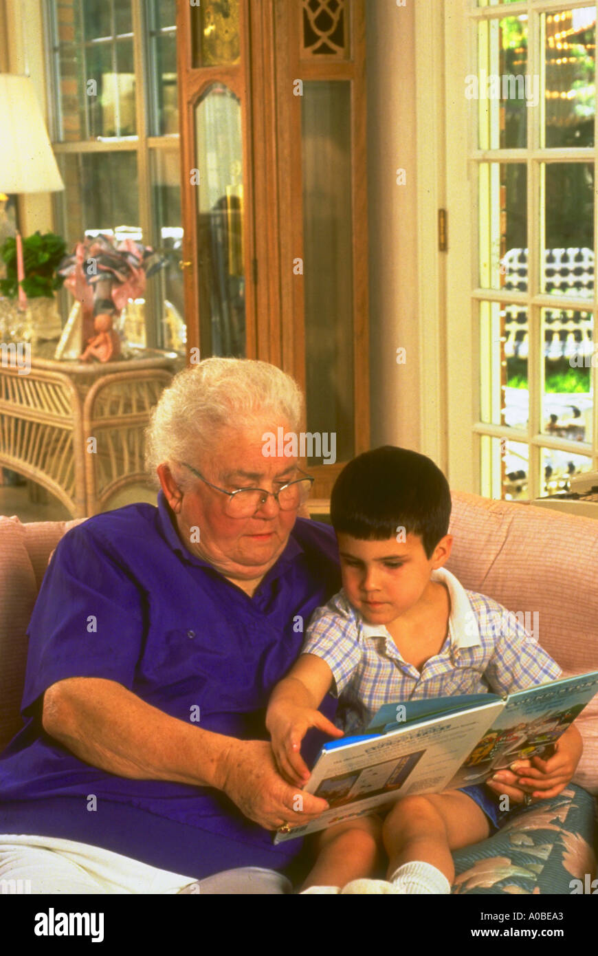 Child being read to by his grandmother in Florida living room Stock Photo