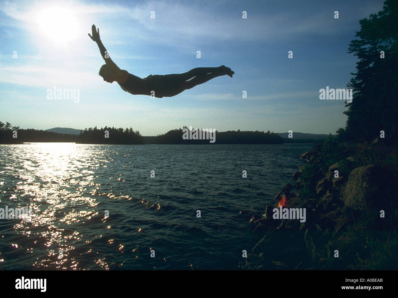 Boy diving into Lake near Camden Maine at sunset model released Stock ...