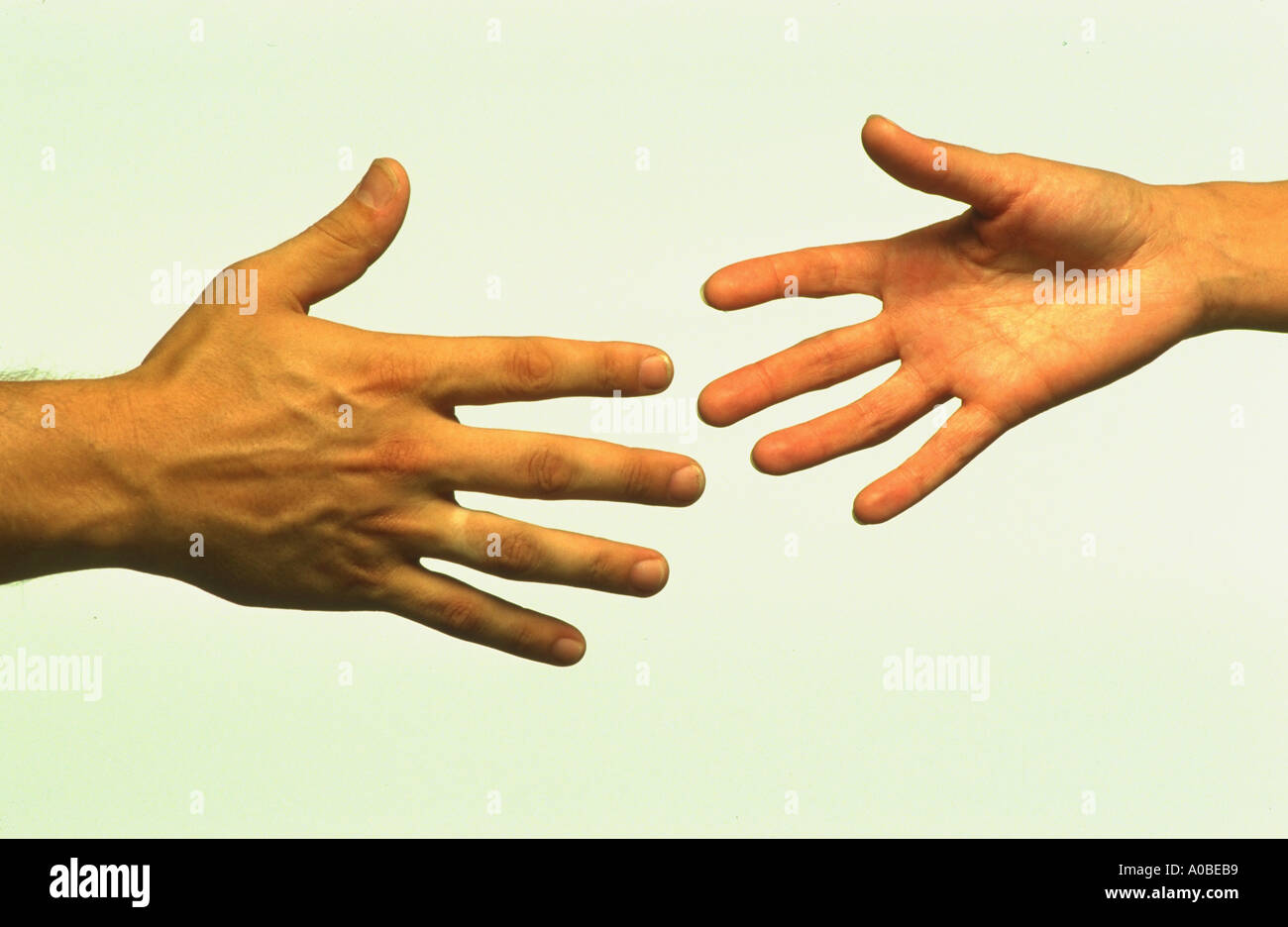 Hands reaching out and almost touching Stock Photo