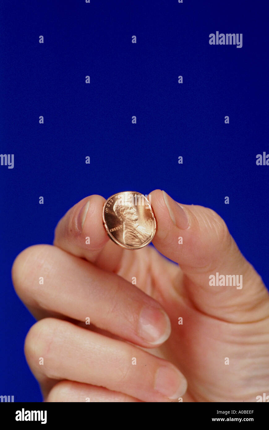 Penny pincher Hand pinching a penny Trying to get the most value out of
