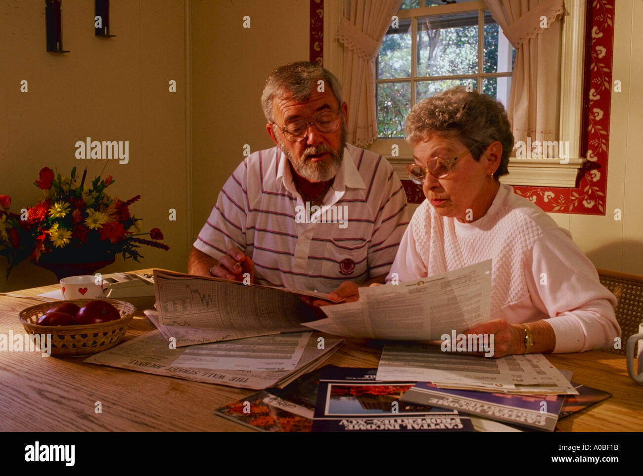 Mature couple works on personal finances at their kitchen table Stock Photo