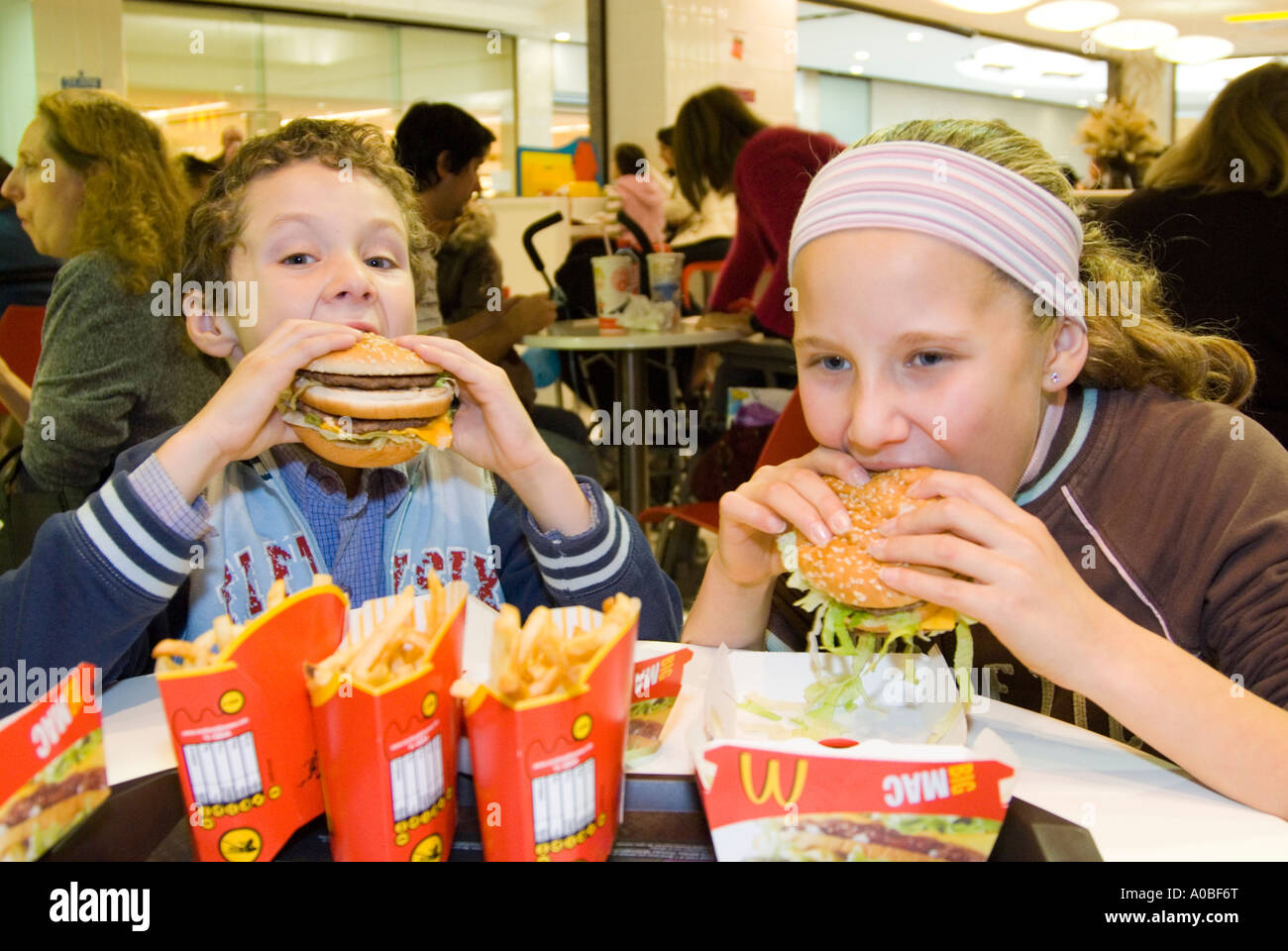 Children eating McDonald's Big Mac hamburgers England UK Stock Photo