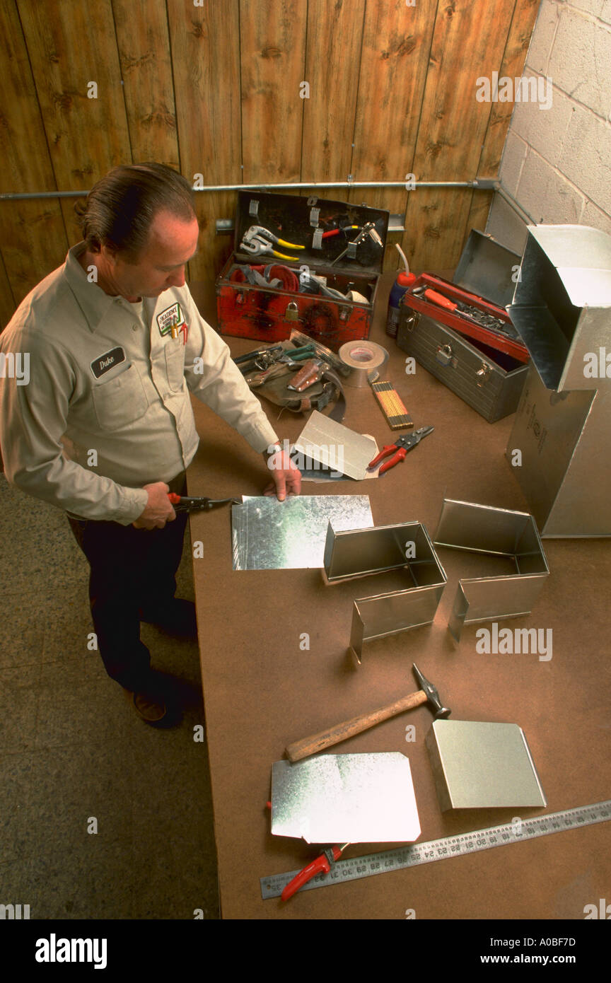 Sheet metal worker working on ducts for heading unit released CF39771 Stock Photo