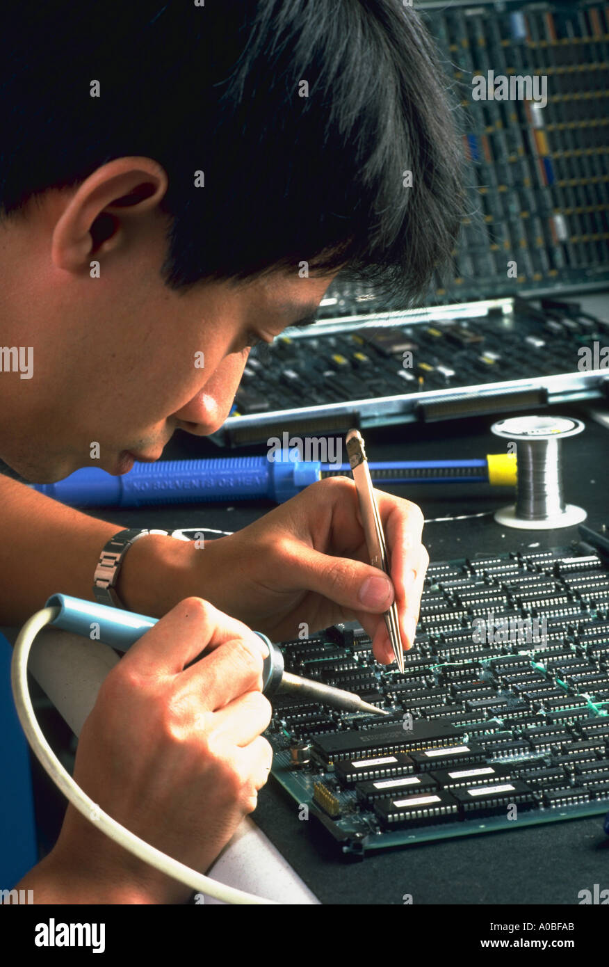 Vietnamese worker repairs circuit board at Filenet in Costa Mesa CA released BC 2737 Stock Photo