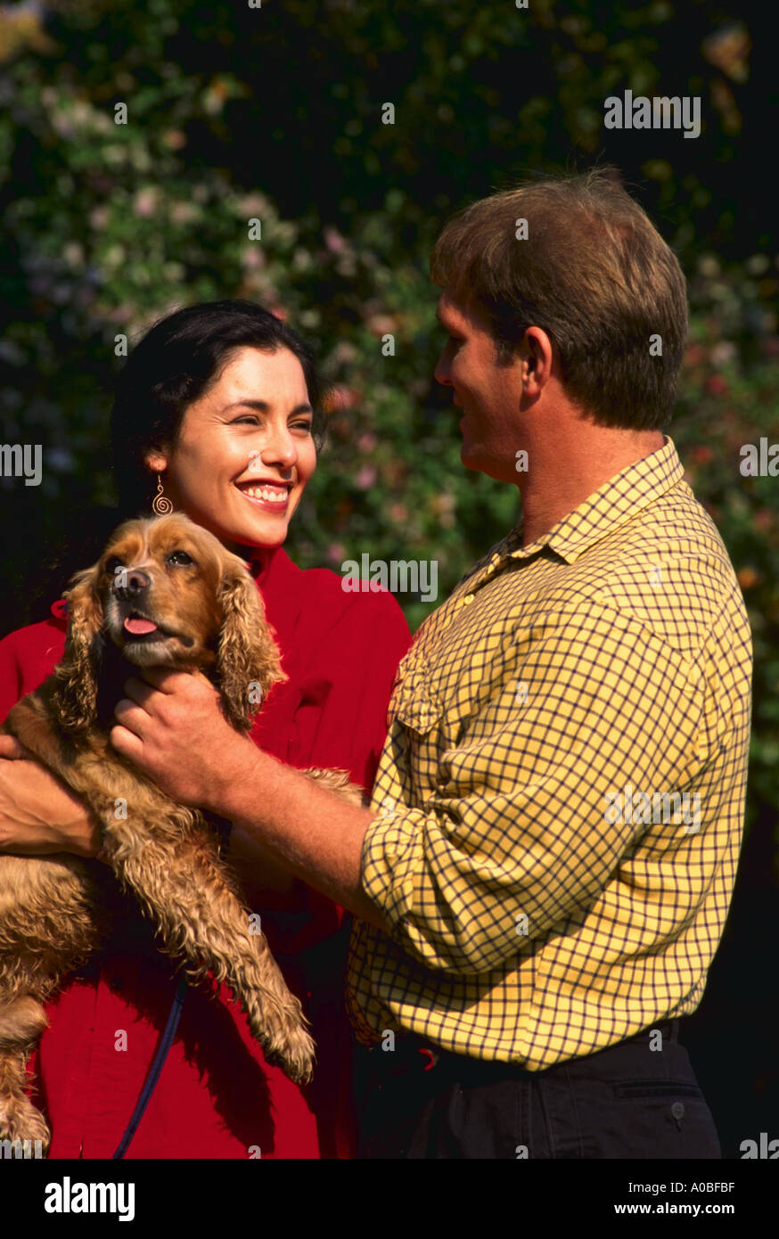 Young couple walking dog in the park Stock Photo