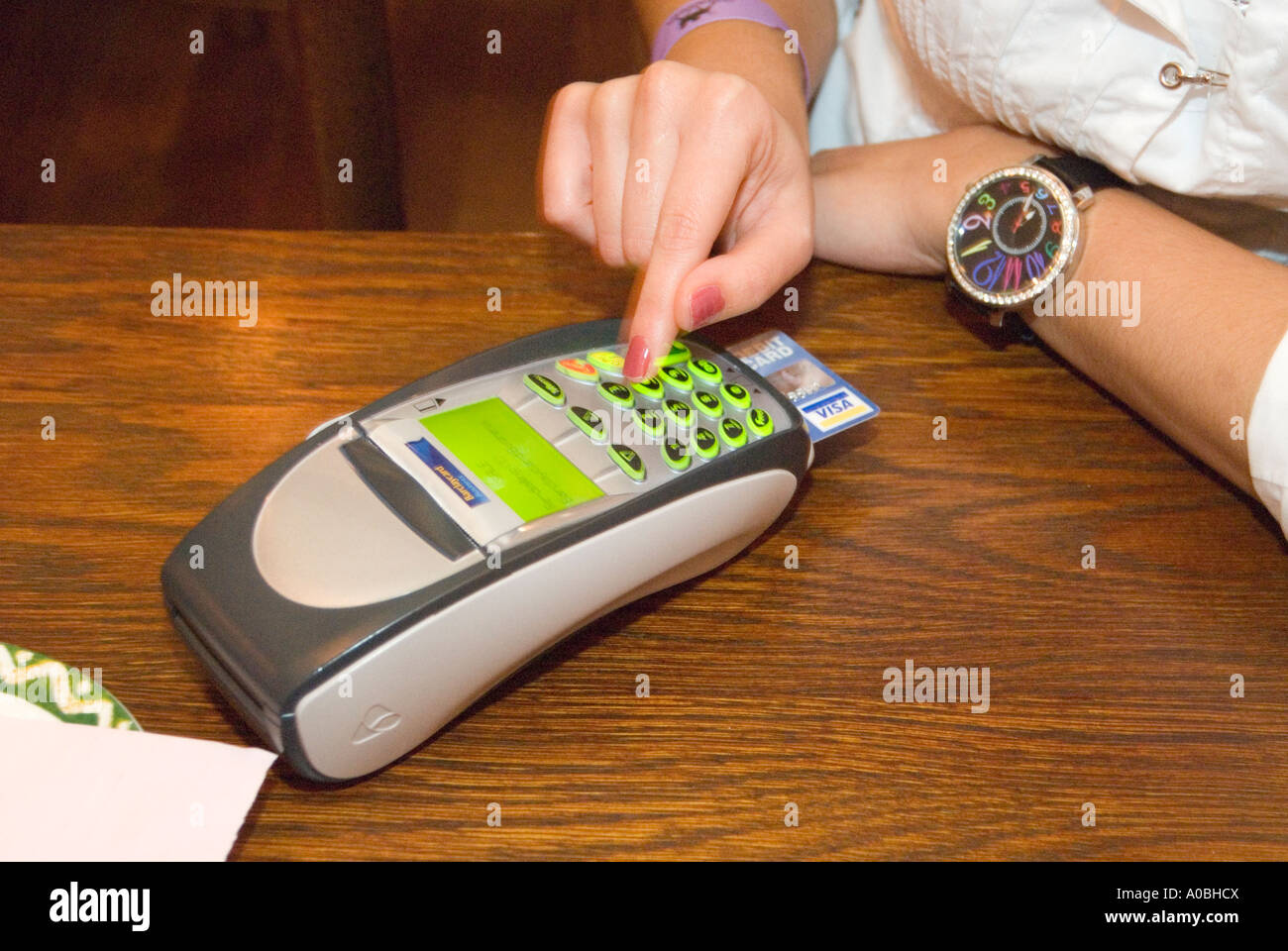 Woman paying restaurant bill with chip and pin machine, England UK Stock Photo