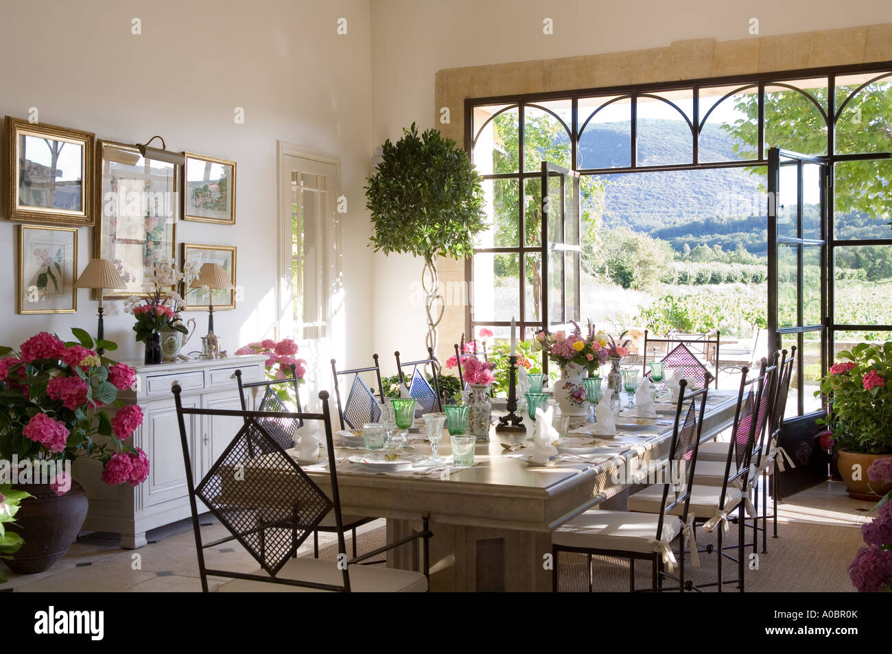Dining room table set in room with open double doors Stock Photo - Alamy