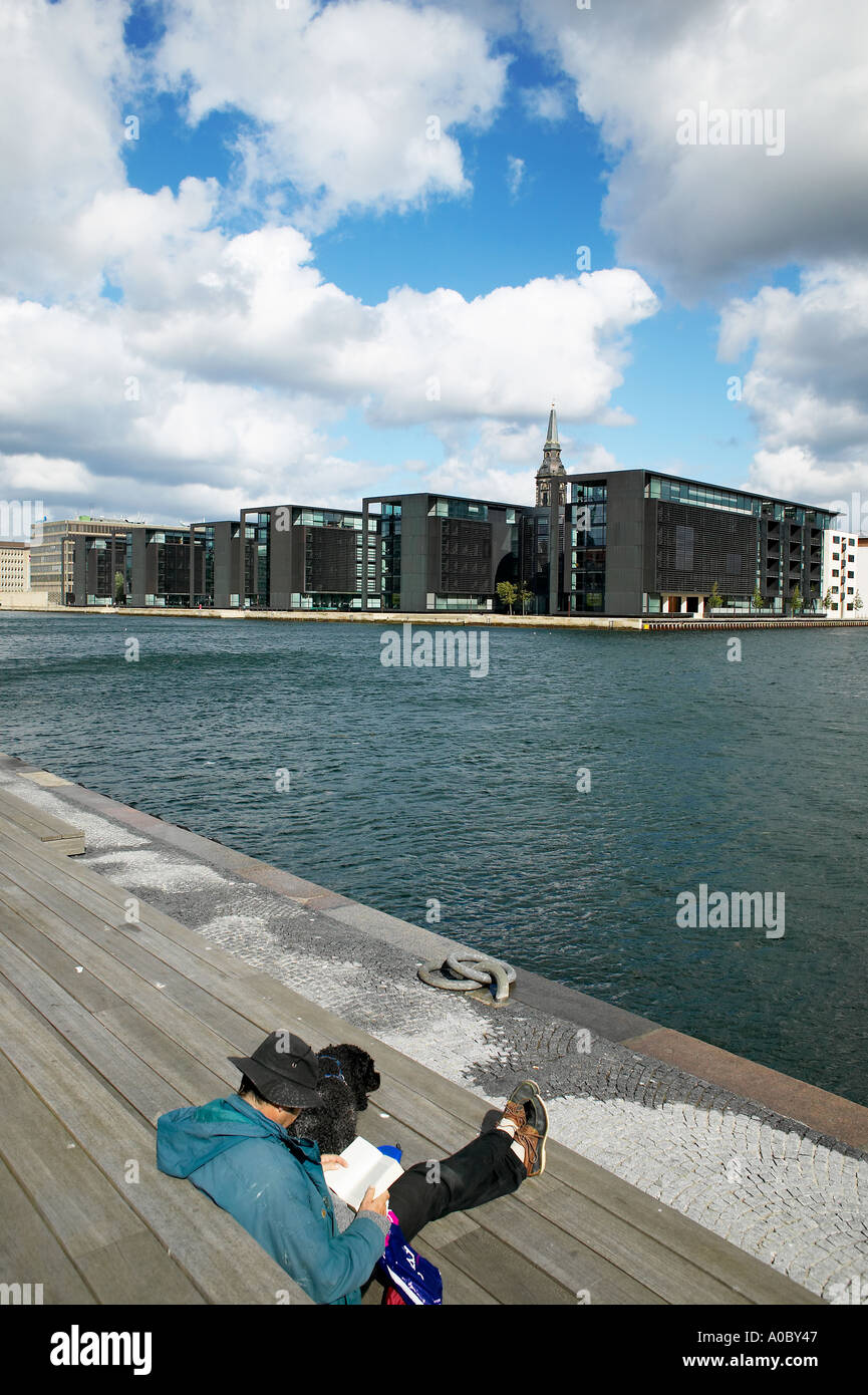 Man reading on pier and Nordea Bank headquarters in Christianhavn, Copenhagen, Denmark Stock Photo
