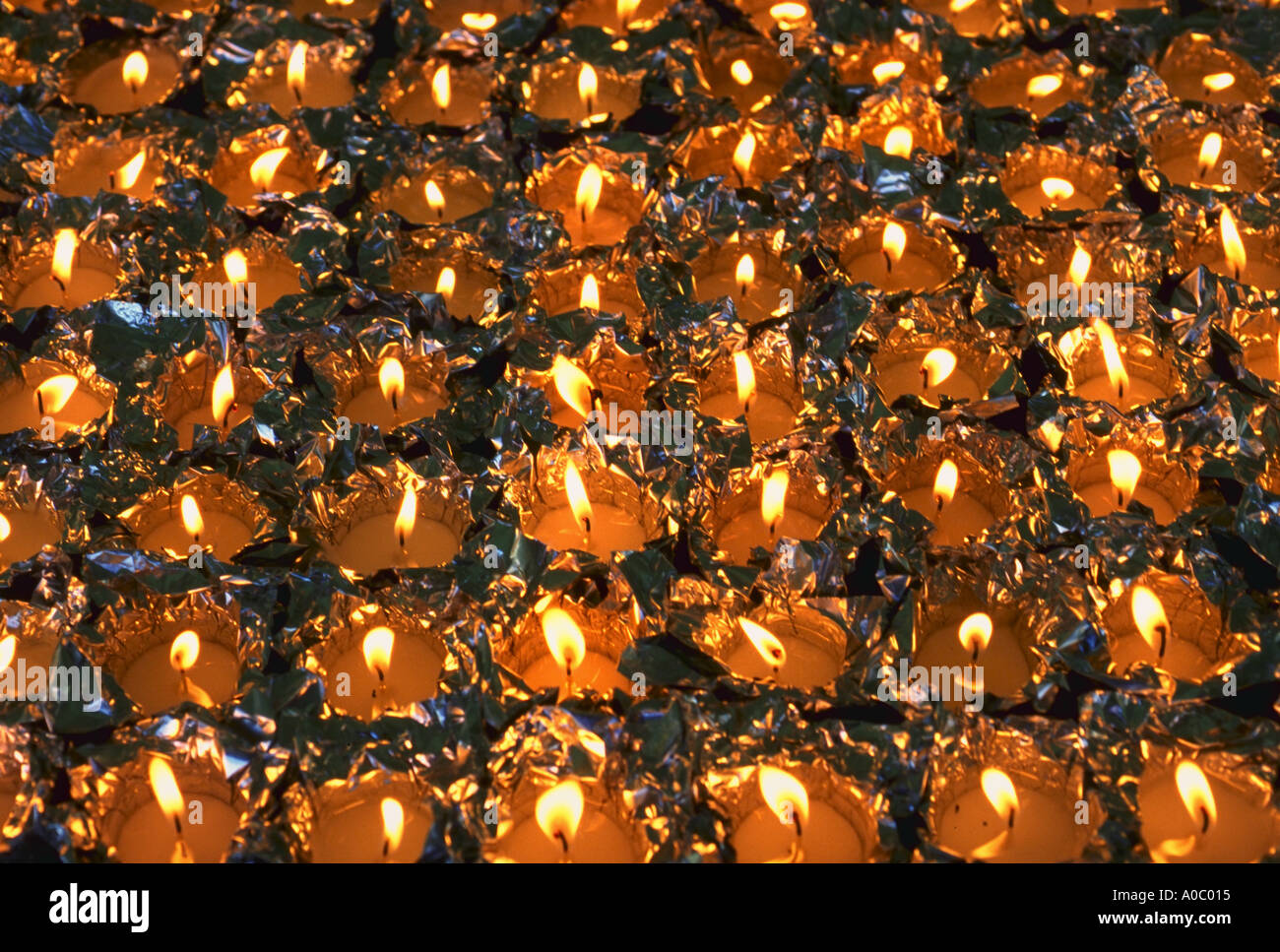 Rows of lit candles in aluminum foil Stock Photo Alamy