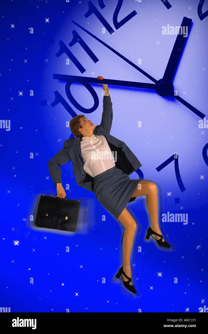 Businesswoman hanging off giant clock hand Stock Photo Alamy