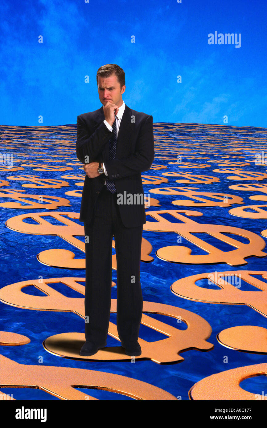 Businessman standing on money thinking Stock Photo