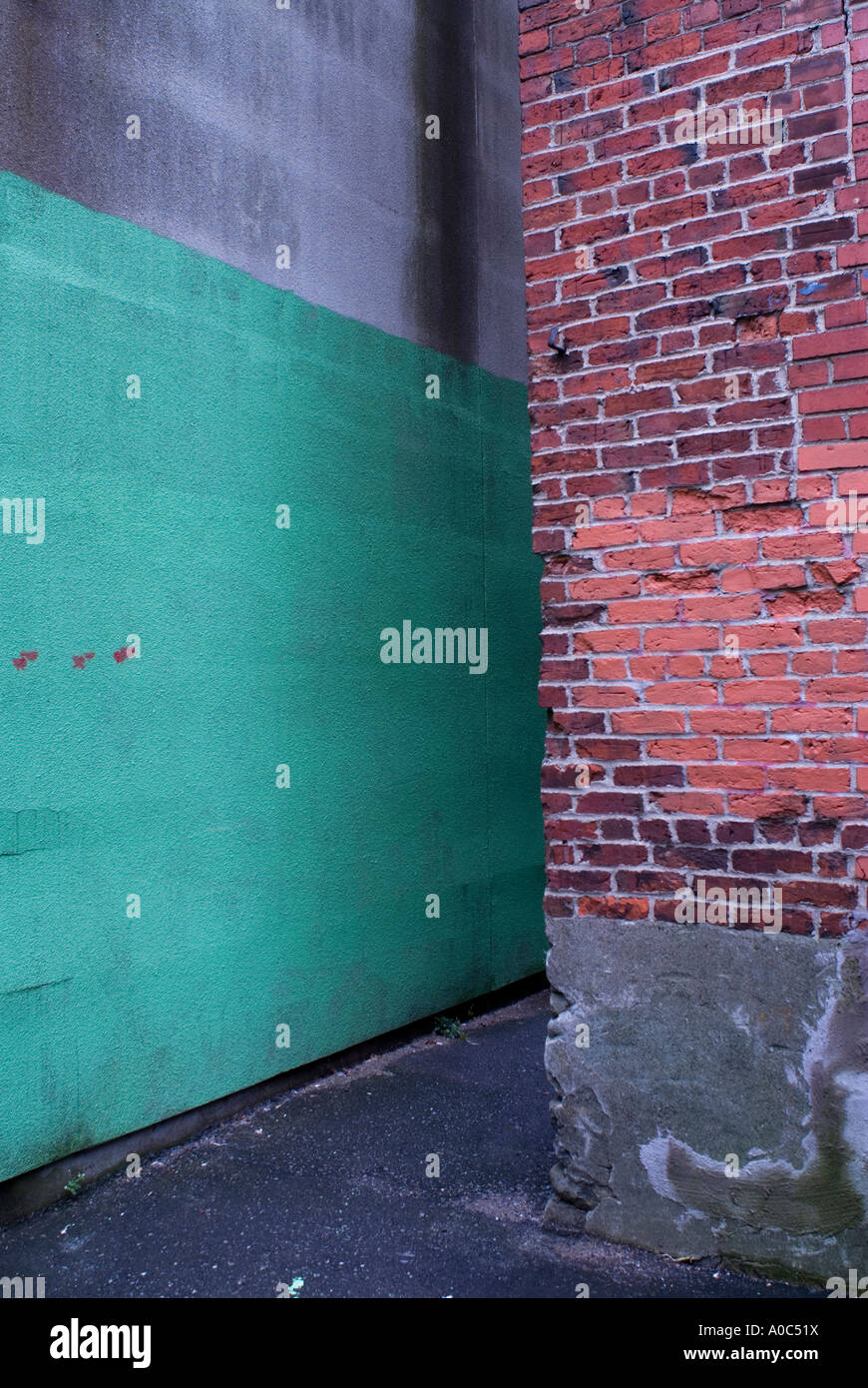 Stock image of a back alley framed by a brick building and green