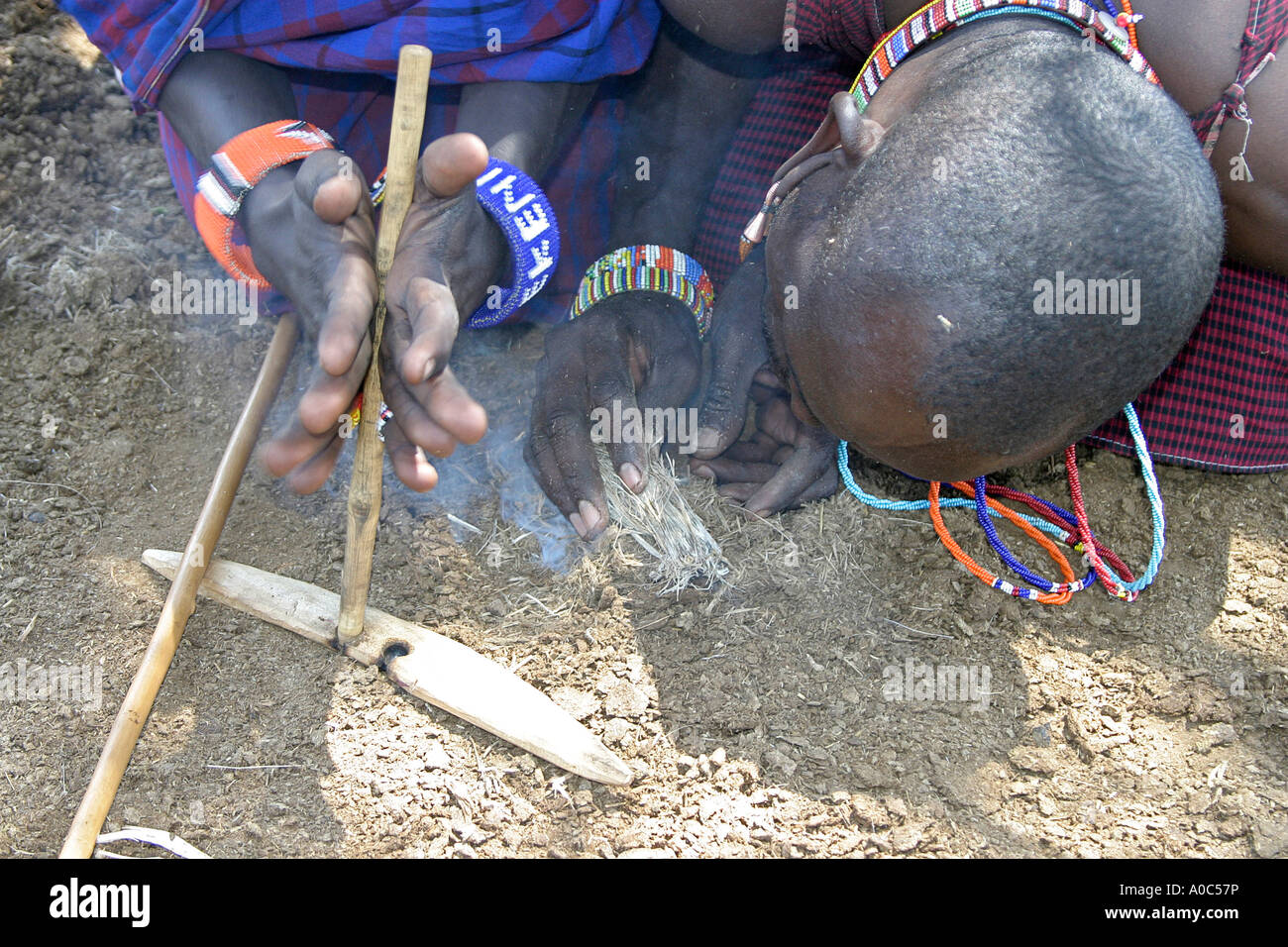 Maasai man lights fire by twirling sticks Stock Photo