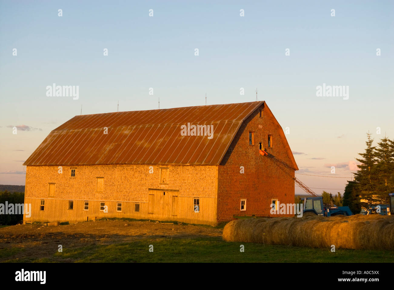 Stock image of large wooden barn with round hay bales infront of it at ...
