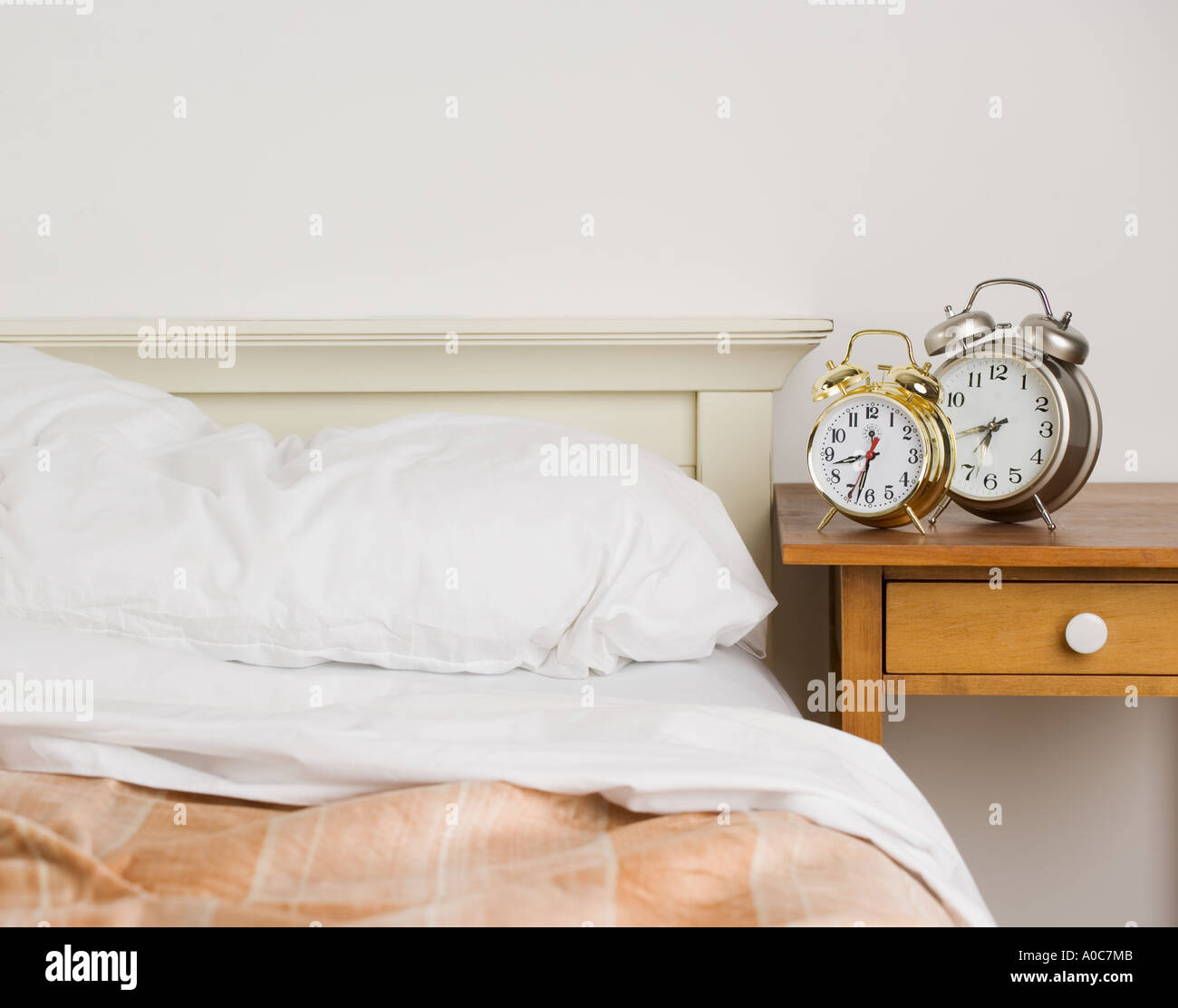 Unmade bed with alarm clocks Stock Photo Alamy