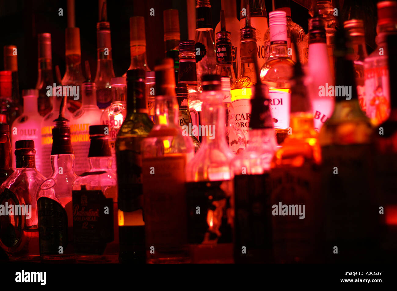 Bottles of spirits by night lit with a red lamp from a beach side bar in Dubai Stock Photo