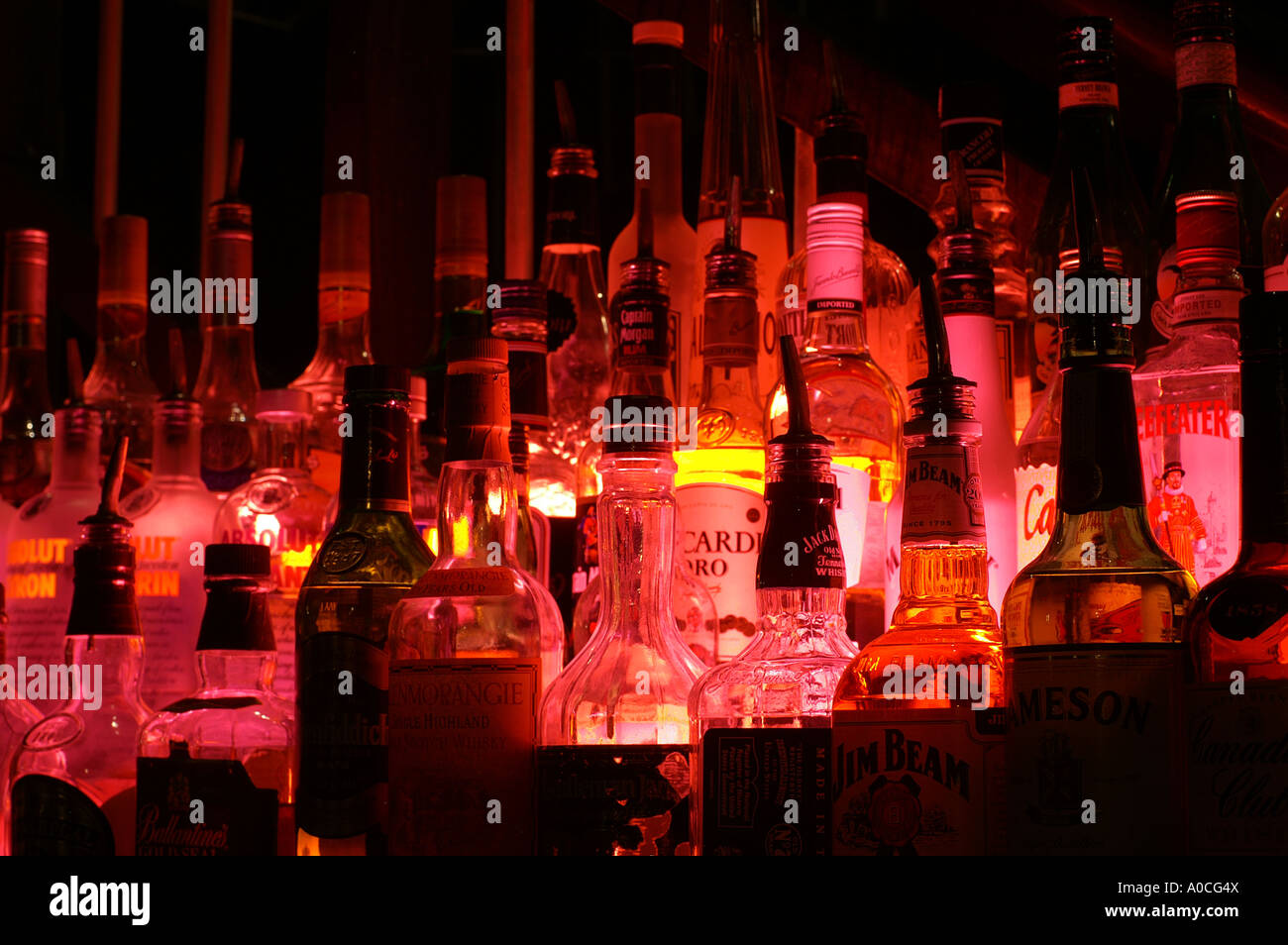 Bottles of spirits by night lit with a red lamp from a beach side bar in Dubai Stock Photo