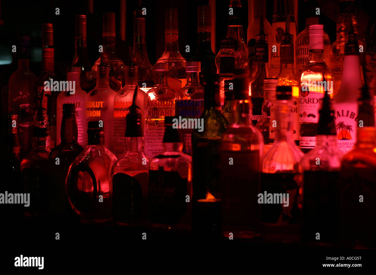 Bottles of spirits by night lit with a red lamp from a beach side bar in Dubai Stock Photo