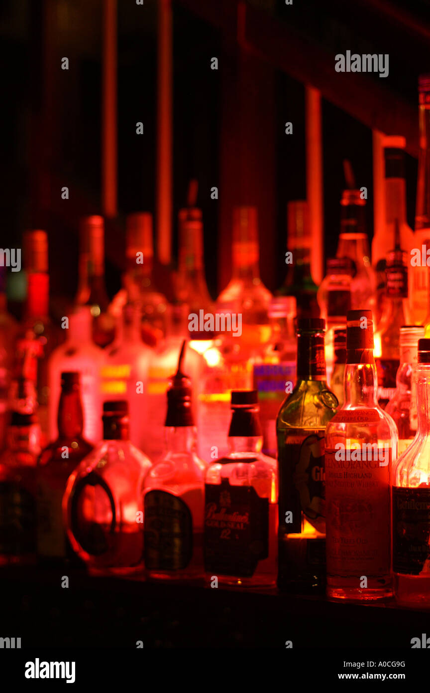 Bottles of spirits by night lit with a red lamp from a beach side bar in Dubai Stock Photo