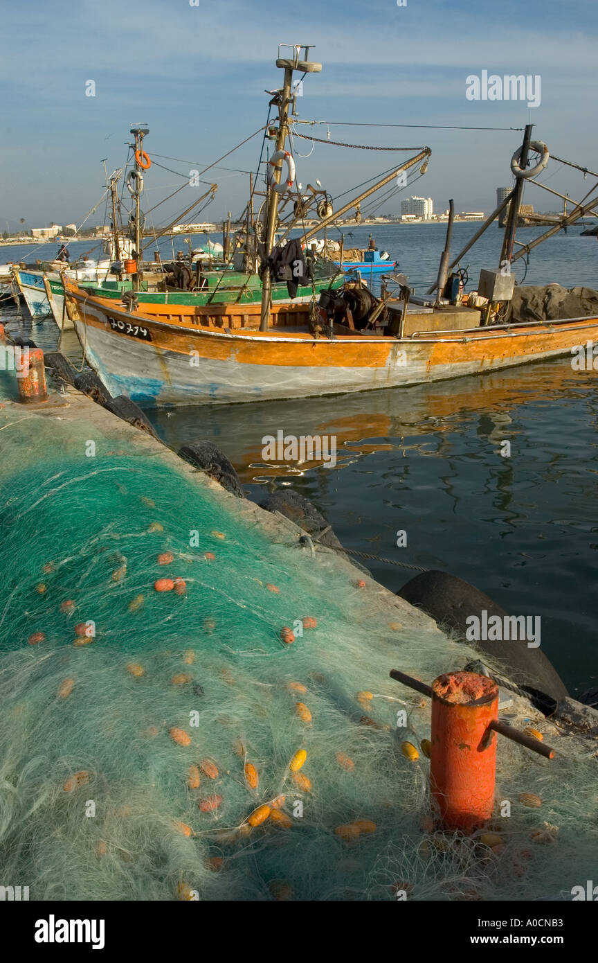Israel Akko old city the old harbour fishing nets in frgd and fishing boats in bkgd vertical Stock Photo
