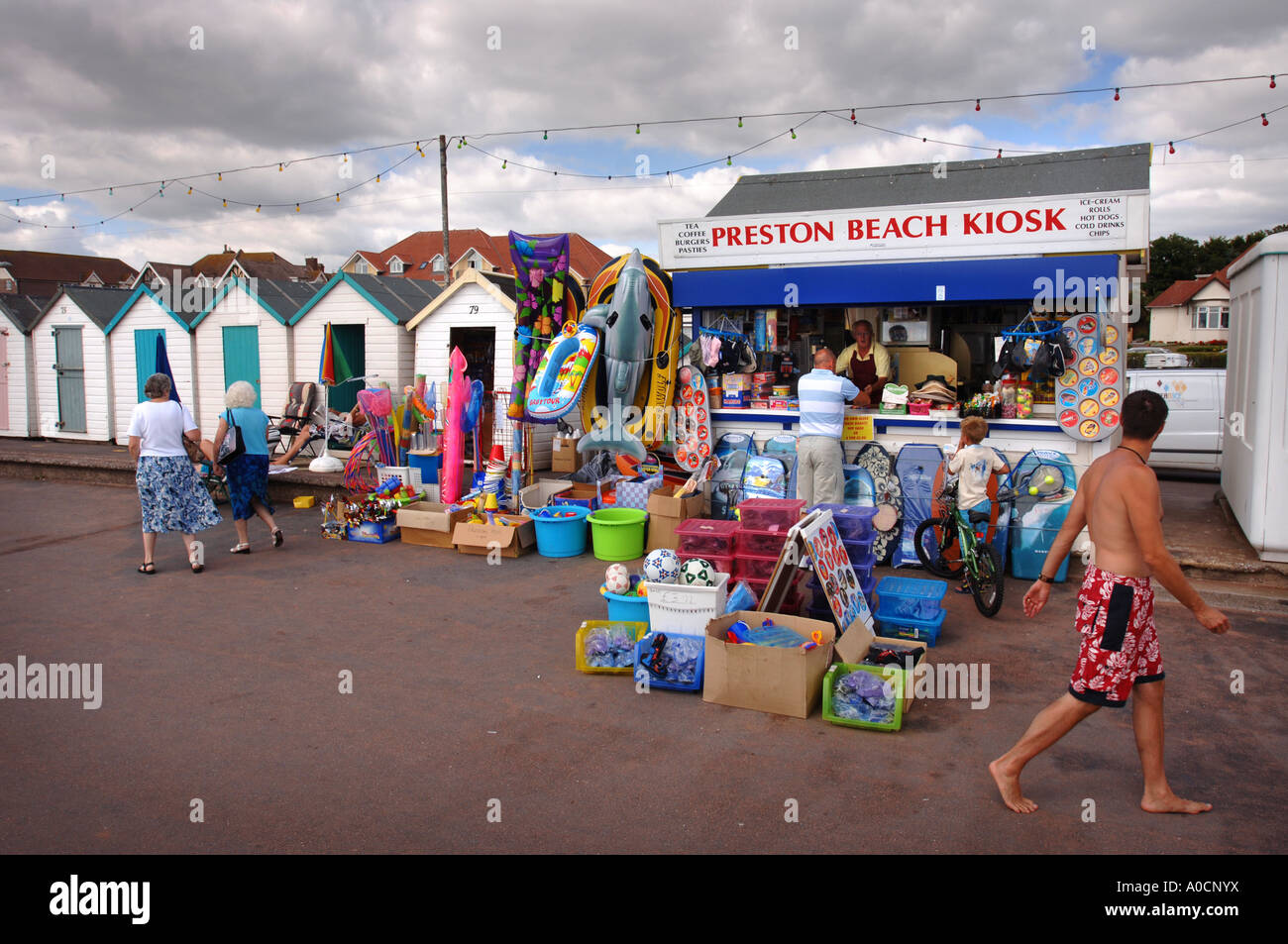 THE PRESTON BEACH KIOSK ALONGSIDE BEACH HUTS ON THE PROMENADE AND MARINE PARADE AT PAIGNTON DEVON UK Stock Photo