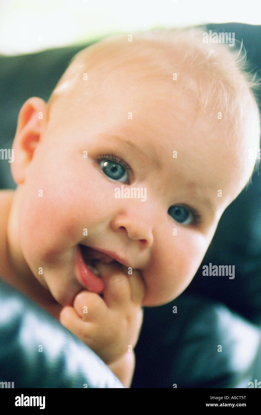 Portrait of baby girl with fingers in mouth Stock Photo