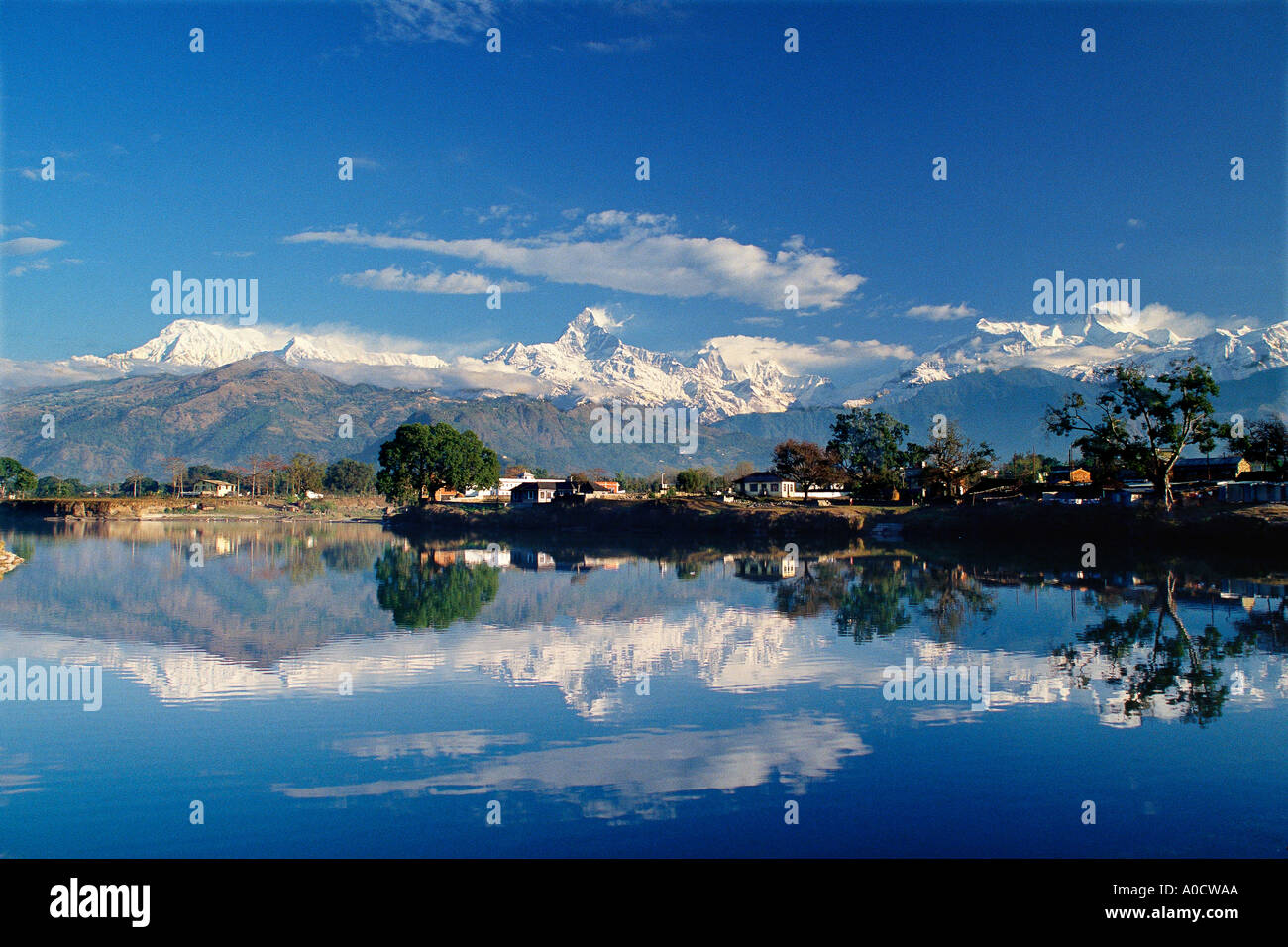 An early morning view of the Annapurna range and its reflection in Lake Tal Pokhara Nepal Stock Photo