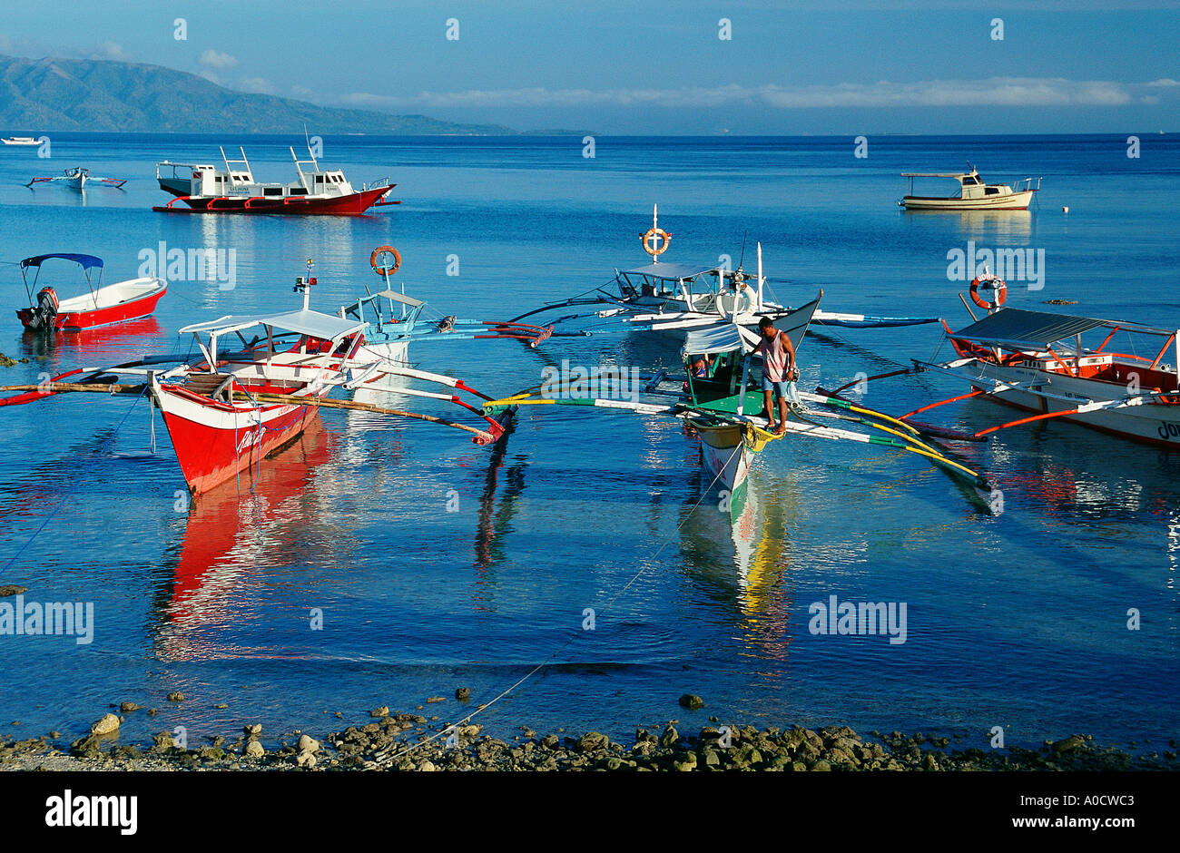 Outrigger boats or banca moored in the shallows close to a beach Big La Laguna Beach Puerto Galera Mindoro Philippines Stock Photo