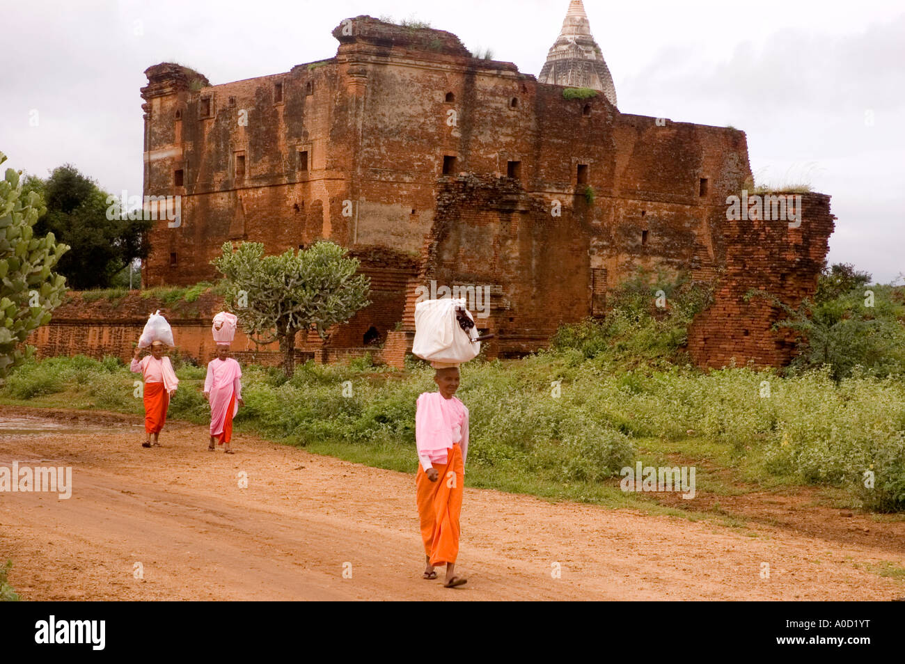 Stock photograph of Buddhist nuns walking past Leimyethna Pahto at Bagan in Myanmar 2006 Stock Photo