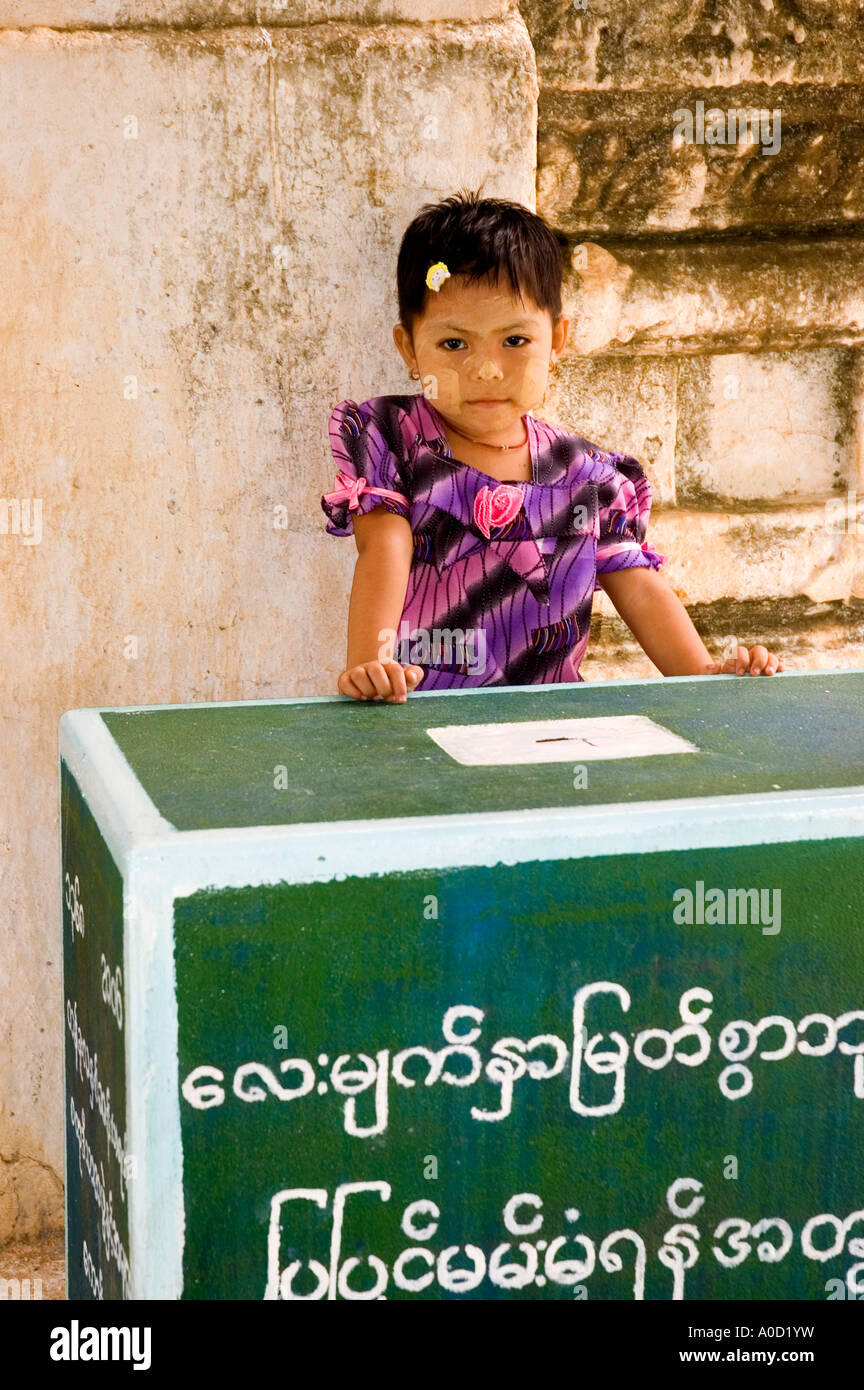 Stock photograph of small girl standing by the donation box at Leimyethna Pahto at Bagan in Myanmar 2006 Stock Photo