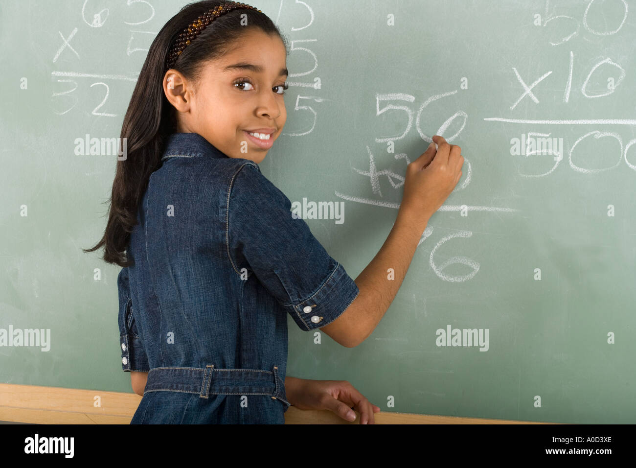 Girl writing on chalkboard Stock Photo