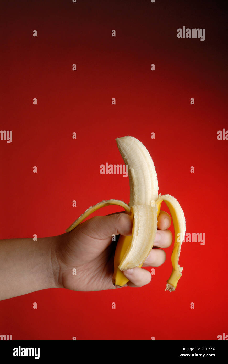 Banana in hand with red background. Stock Photo