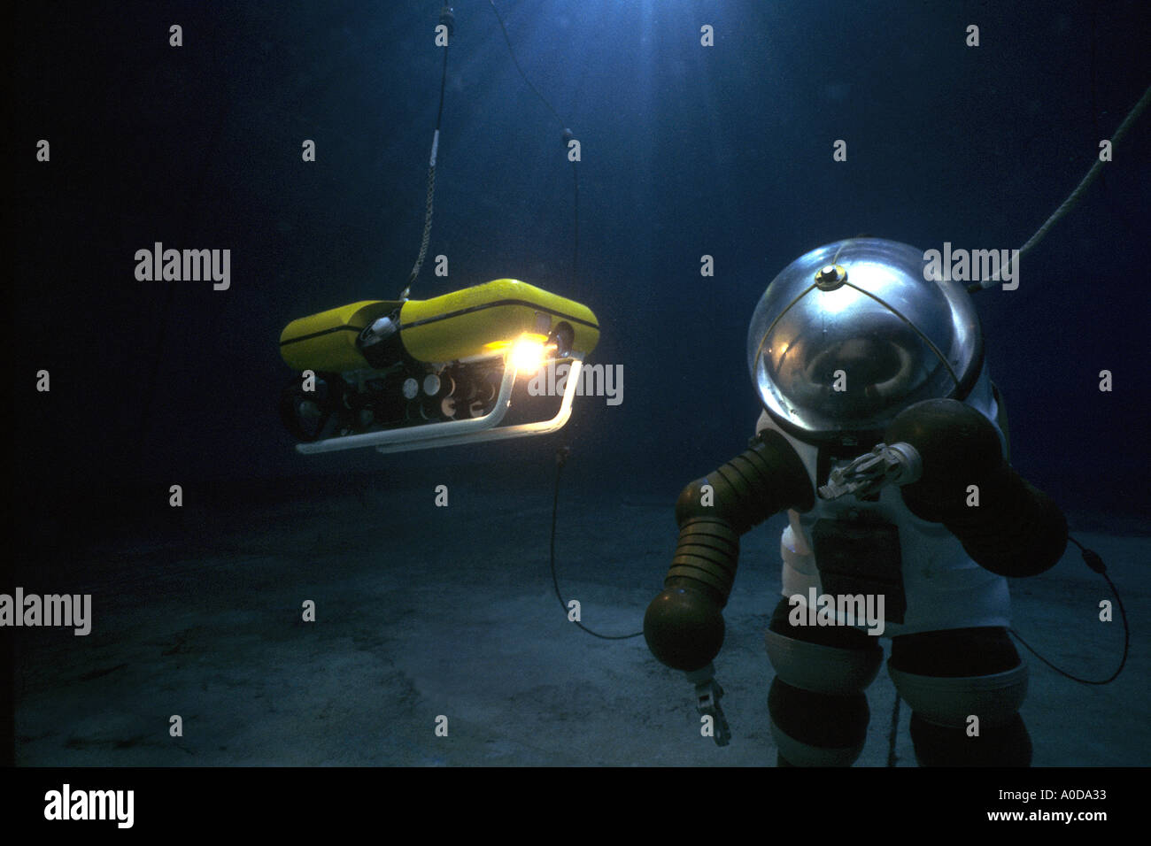 Research commercial deep sea diver in armoured suit with robot submersible Stock Photo