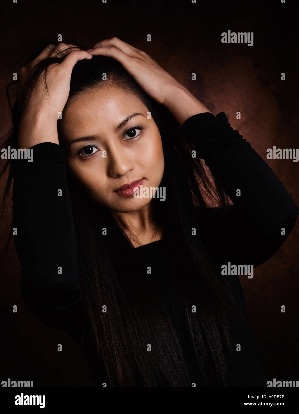 Portrait of oriental woman Vietnamese American with hands in hair Stock Photo