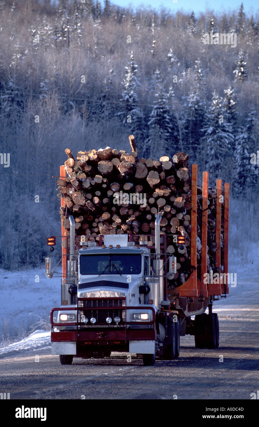 Logging truck in winter on remote road Northern Alberta Canada Stock