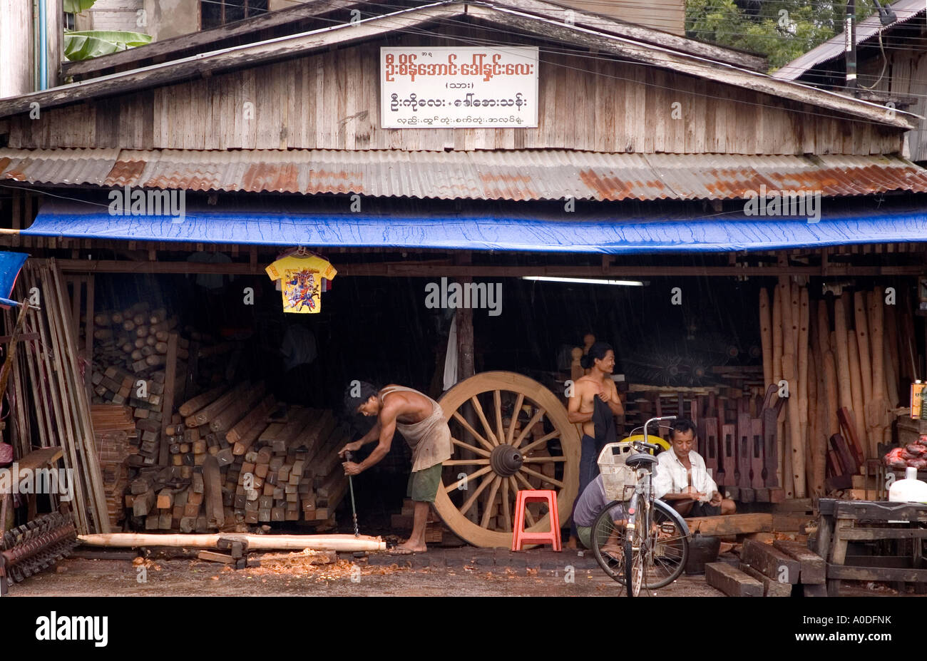 Stock photograph of a workshop hand making ox carts on the main street of  Bago in Myanmar Stock Photo - Alamy