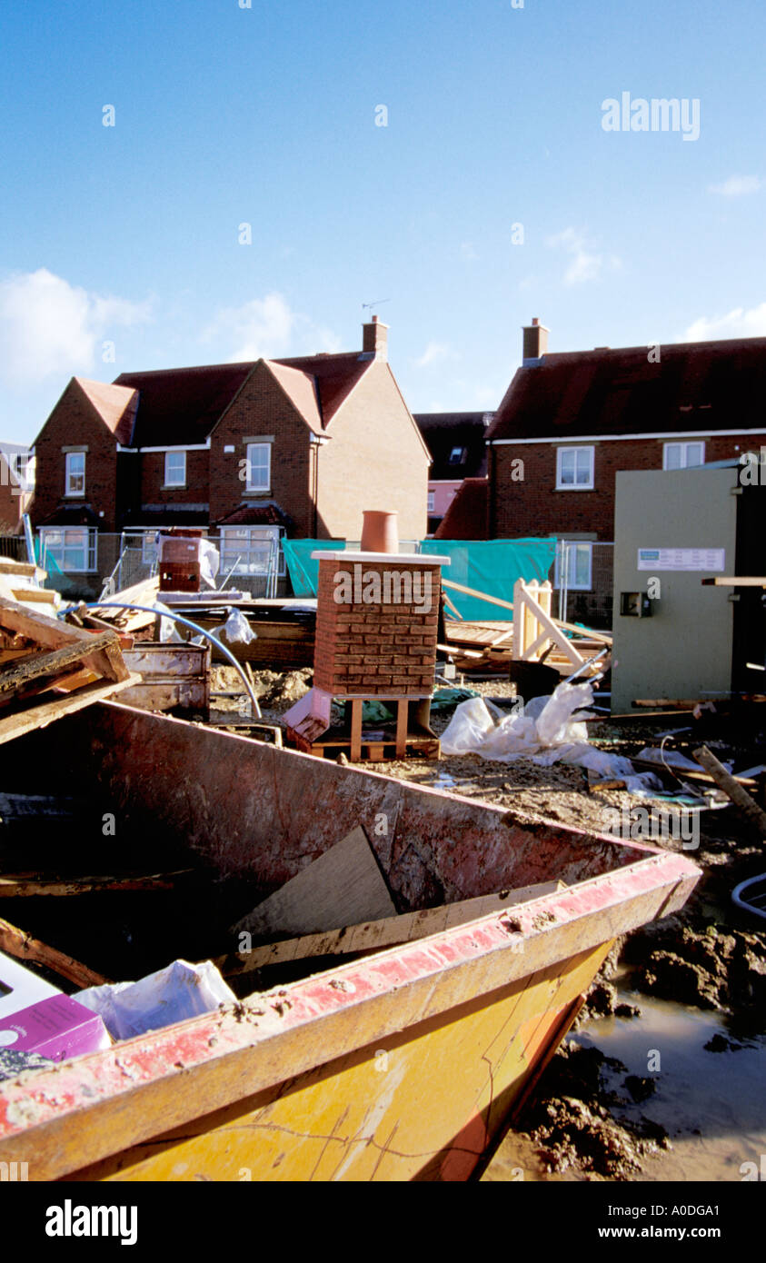 Skip and unused building materials New housing estate Swindon Wiltshire England 2005 Stock Photo