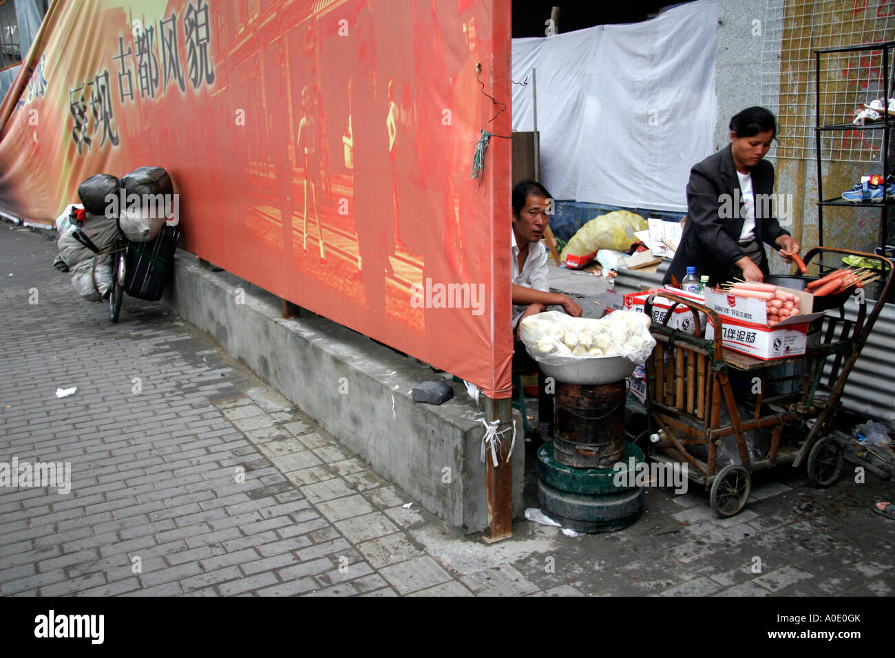 Illicit hot foodstall behind a hording in an area to be demolished for new housing. Due for the Olympic Games, Beijing, China. Stock Photo