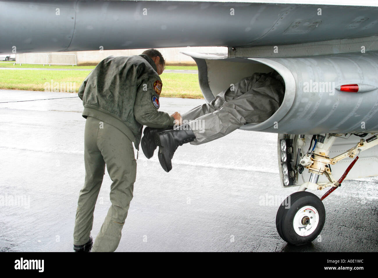 Pilot inspecting jet air intake on F16 fighter plane Stock Photo