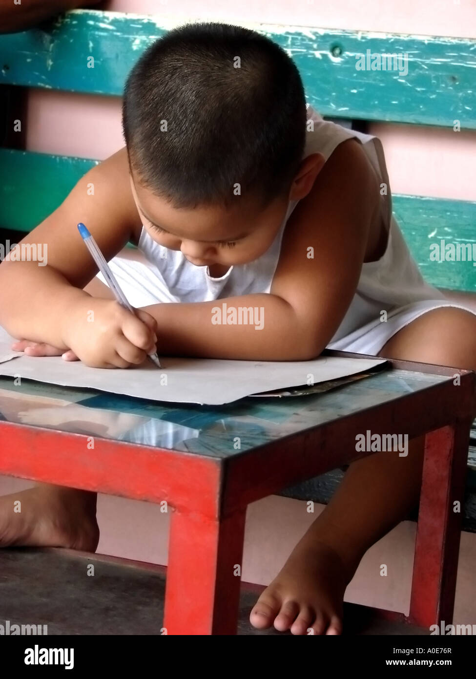 A boy writing on a white cardboard Stock Photo