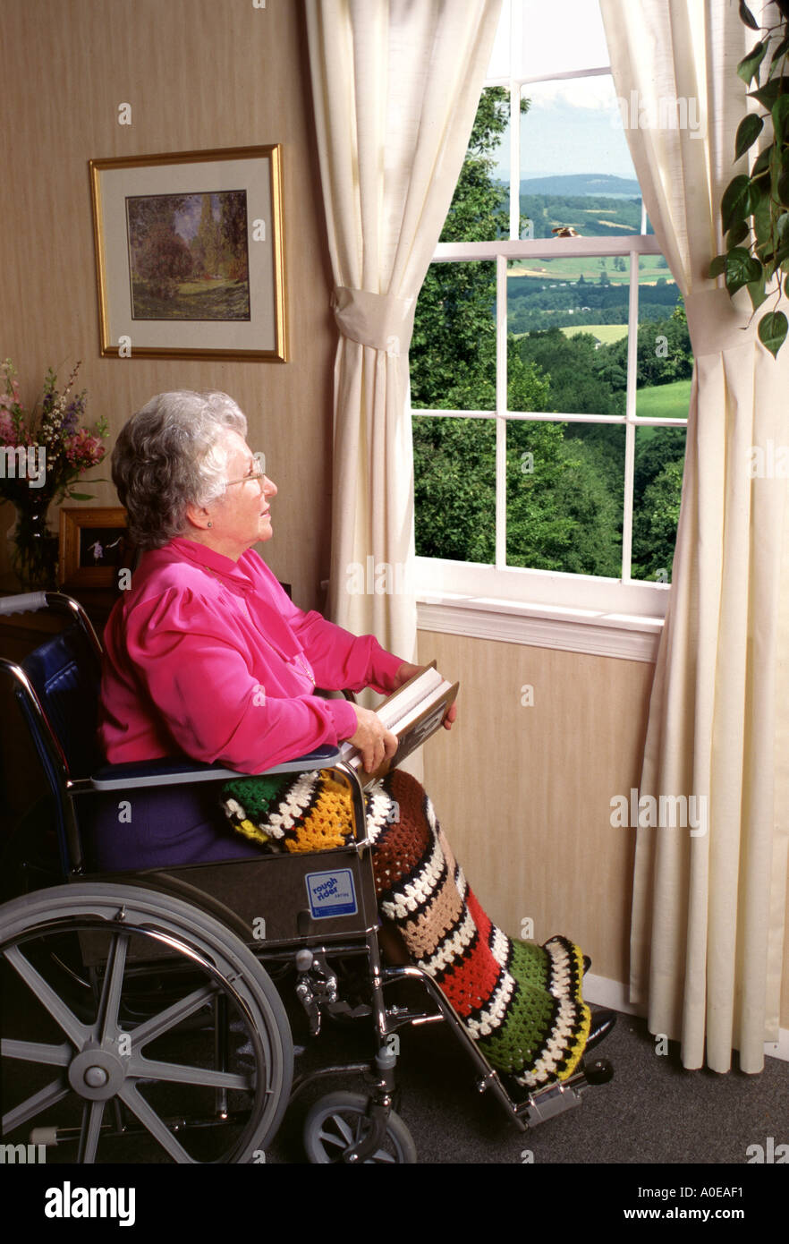 Senior woman in wheelchair looking out window Stock Photo