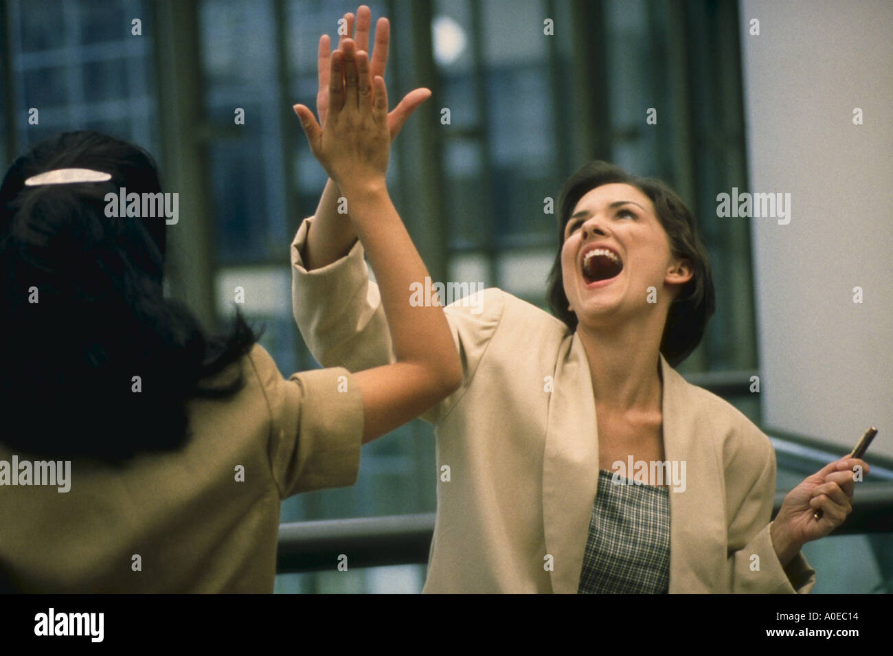 Business women giving eachother high five Stock Photo - Alamy