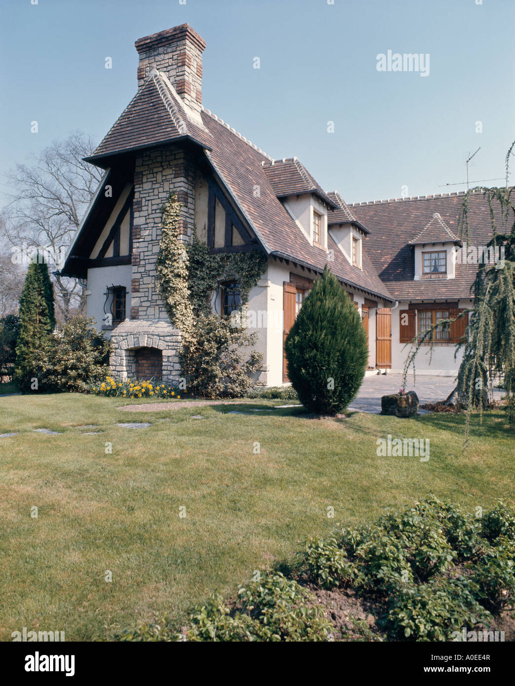 Gabled French House With Dormer Windows And Lawn In Front Stock