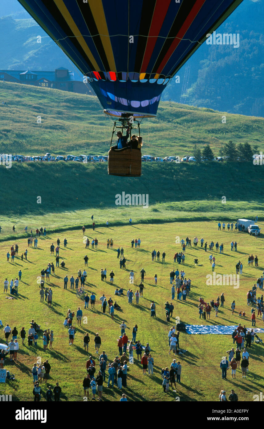 One balloon hovers over crowded field at hot air balloon festival