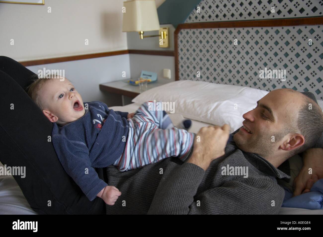father lying with baby on bed Stock Photo - Alamy