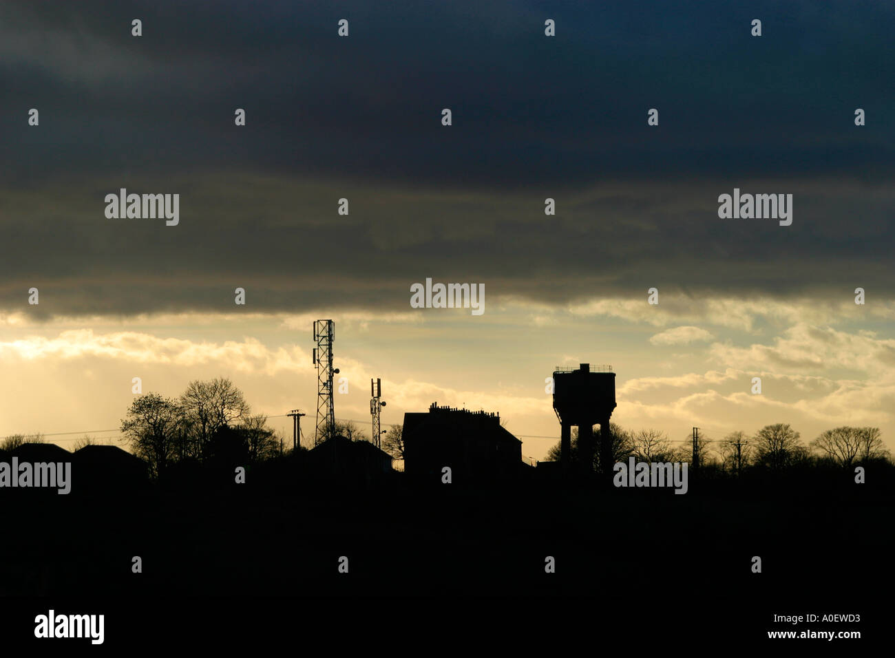 Atmospheric shot of industrial location with houses water tower and mobile phone masts Stock Photo