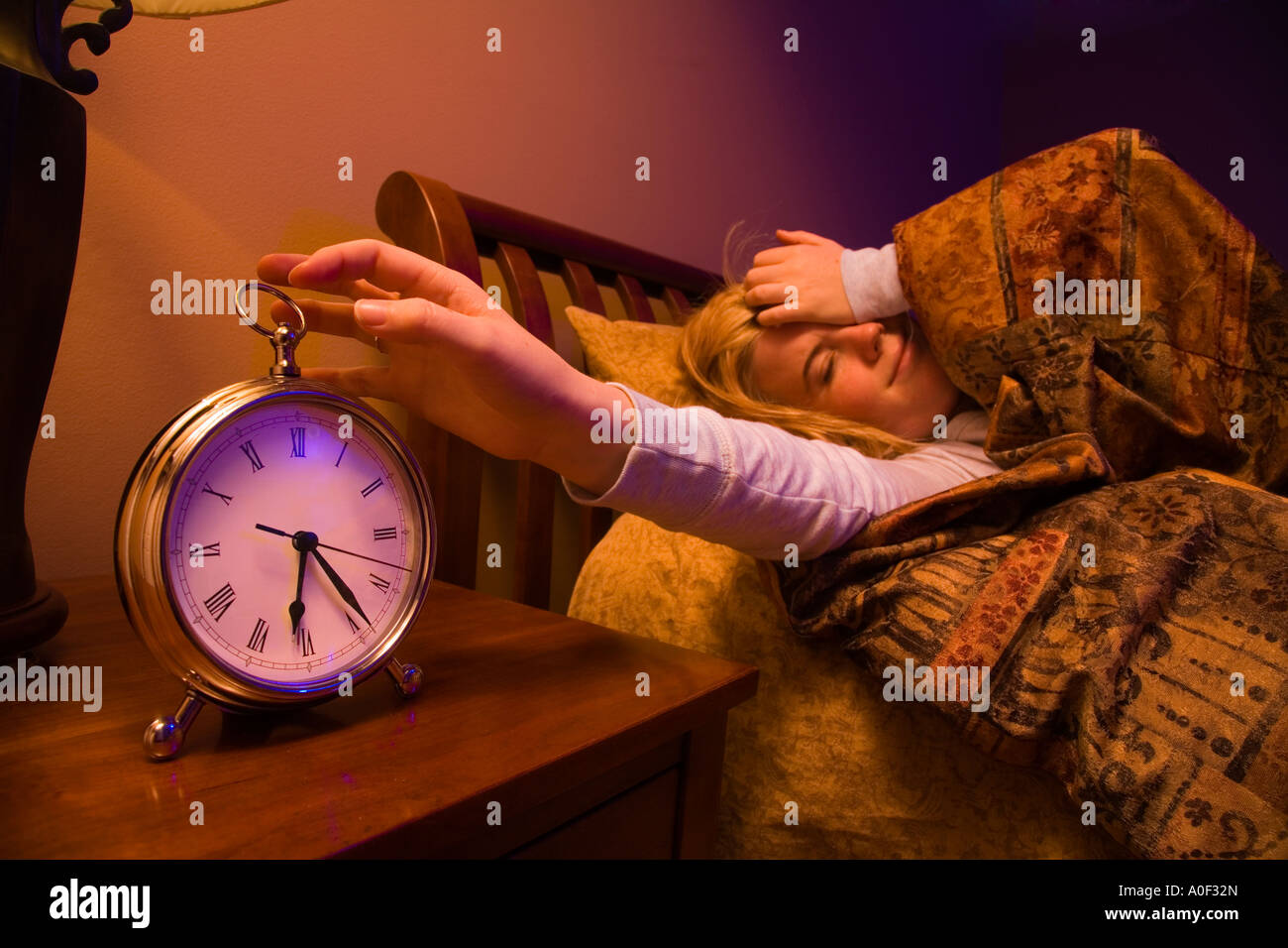 Girl waking up to alarm clock Stock Photo Alamy