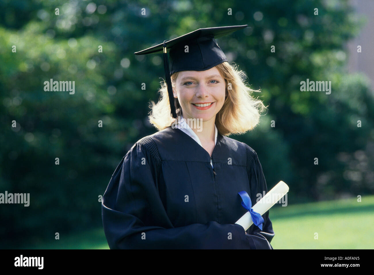 Portrait of a female graduate holding a diploma Stock Photo - Alamy