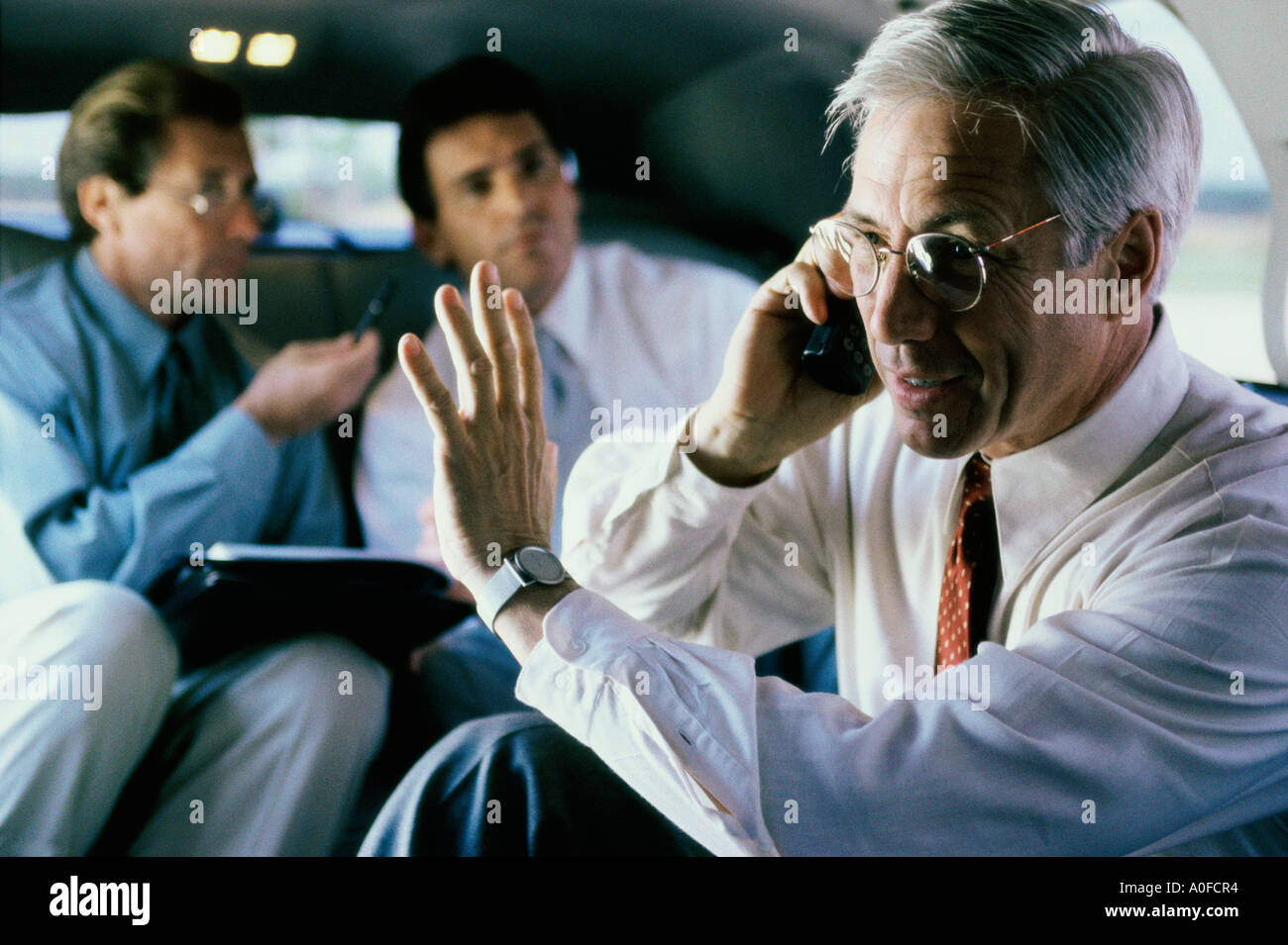 Three businessmen sitting in a car Stock Photo - Alamy